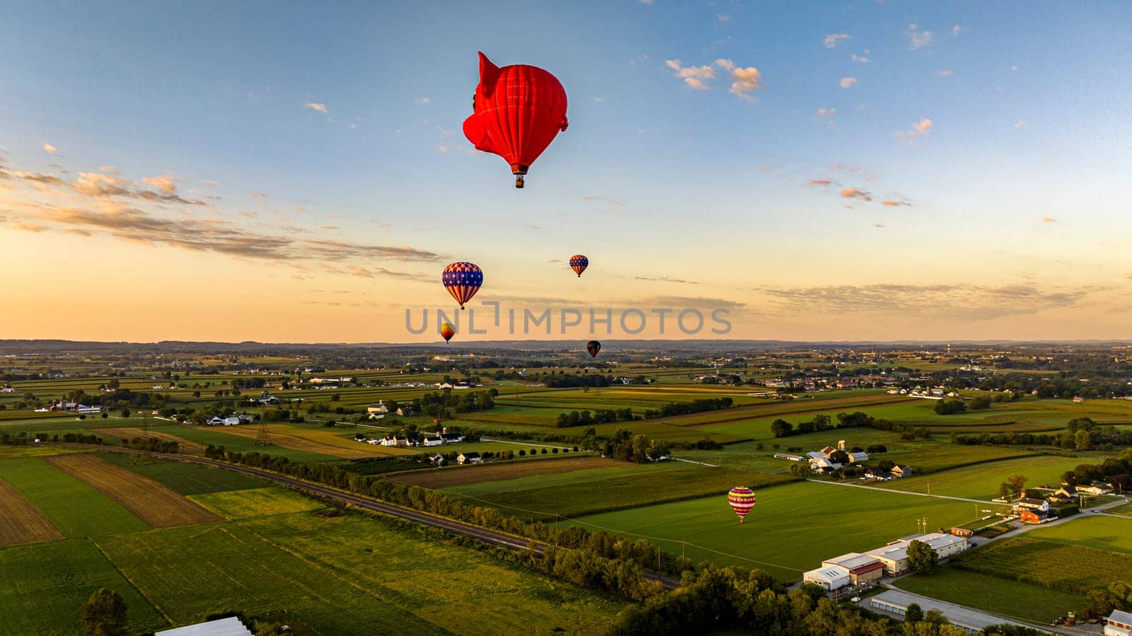 Bird in Hand, Pennsylvania, September 14, 2023 - An Aerial View of Hot Air Balloons Floating Away One is a Pigs Head, in Rural Pennsylvania at Sunrise on a Sunny Summer Morning