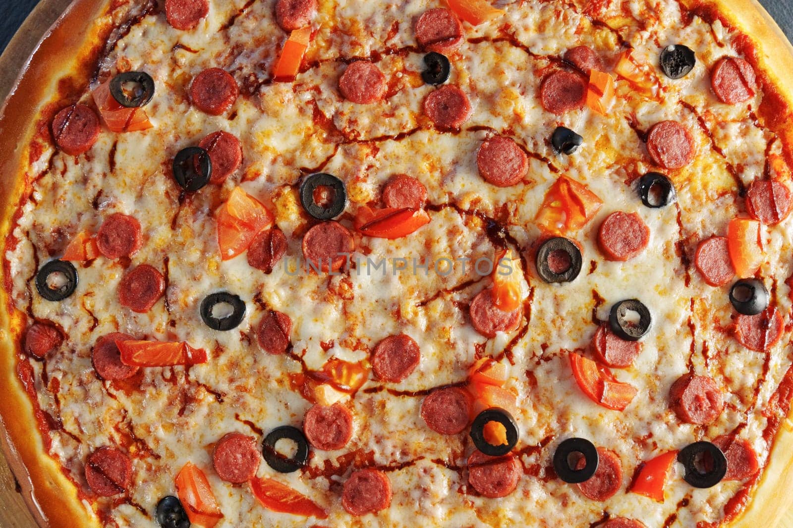 Pepperoni pizza adorned with black olives and red bell pepper slices, presented on a round wooden board by darksoul72