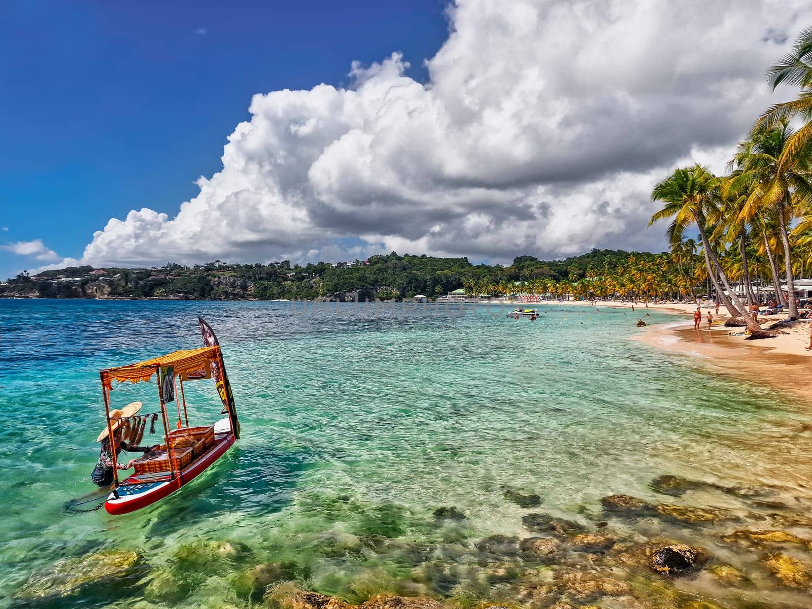 Caribbean island where visitors are served drinks from a small beach boat