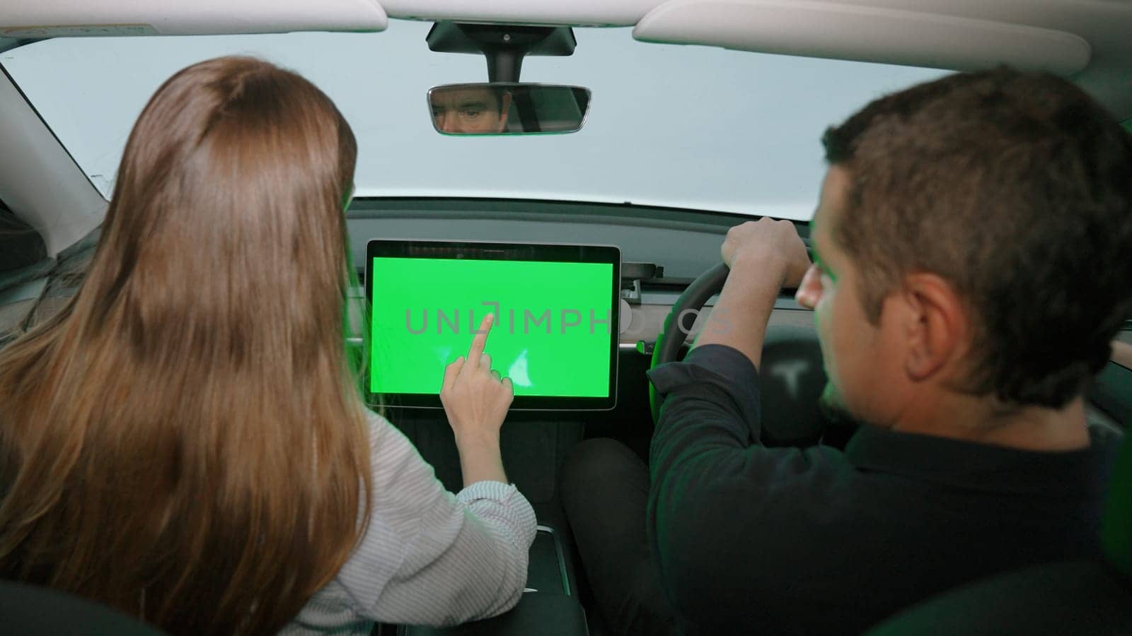 Eco-conscious couple on driver seat holding blank copyspace screen phone. Exalt by biancoblue