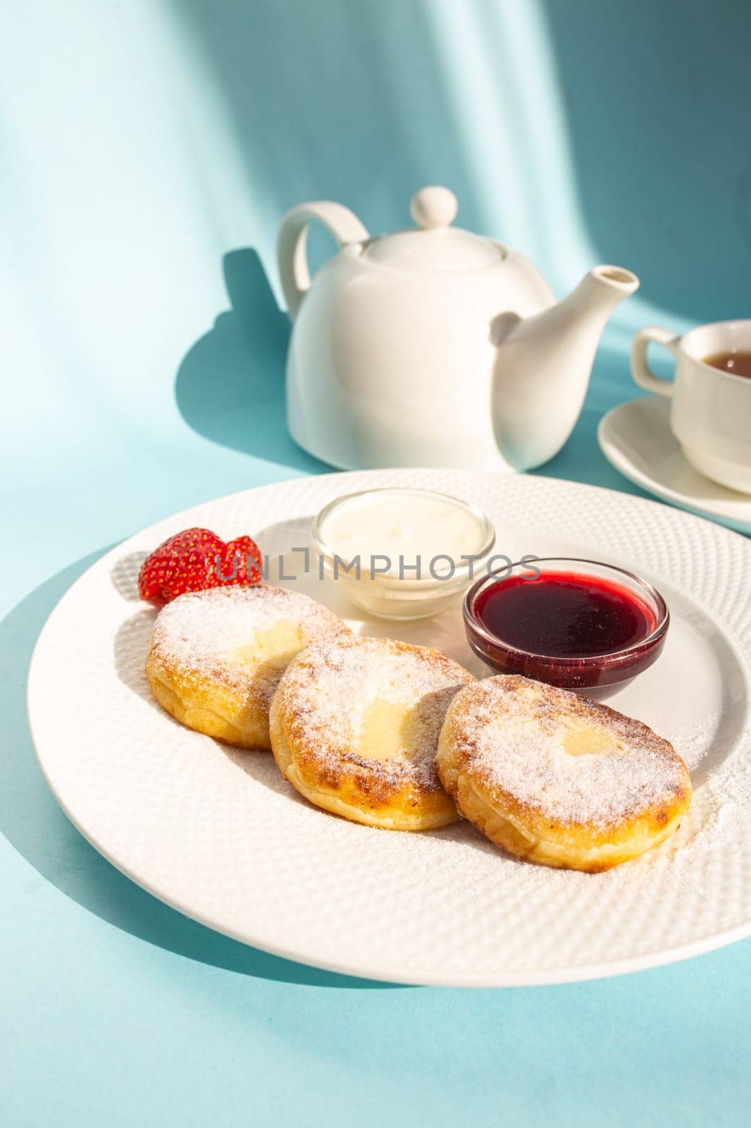 Enjoy a wholesome breakfast with fluffy cottage cheese pancakes topped with jam, fresh strawberries, and a dollop of sour cream. Energize your day with this delicious and nutritious meal.