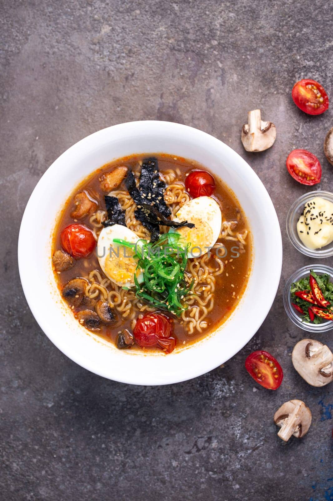 Close-up Savory Ramen Bowl with Colorful Fresh Ingredients on Dark Background by Pukhovskiy