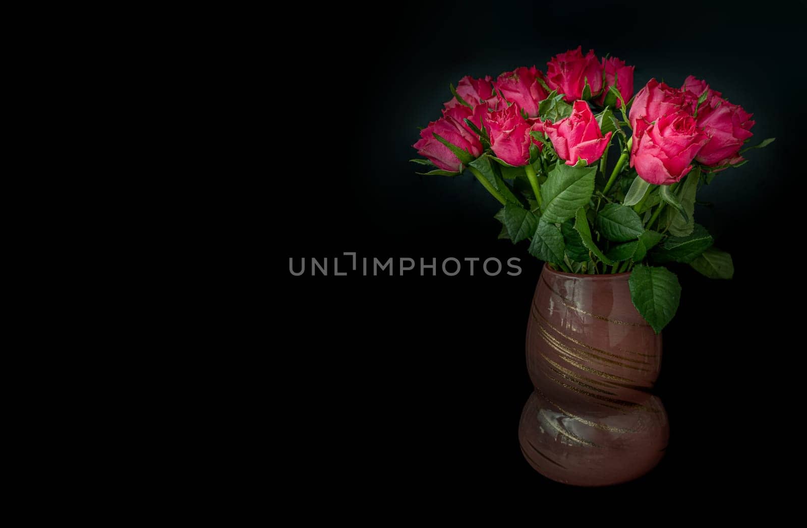 Pretty red-pink roses decorative in a Glass vase on Dark background for Valentine's Day. Symbol of Love, Space for text, Selective focus.