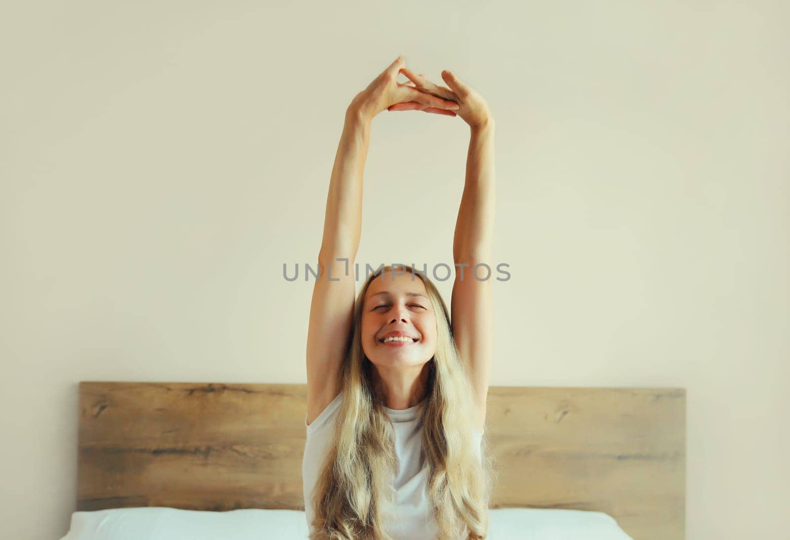 Healthy sleep, relaxed middle aged woman wakes up lying on the bed in bedroom at home