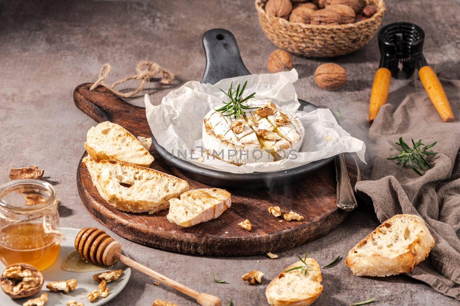 Brie type of cheese. Camembert cheese. Fresh sliced Brie cheese on a wooden tray with nuts, honey and leaves. Italian, French cheese.