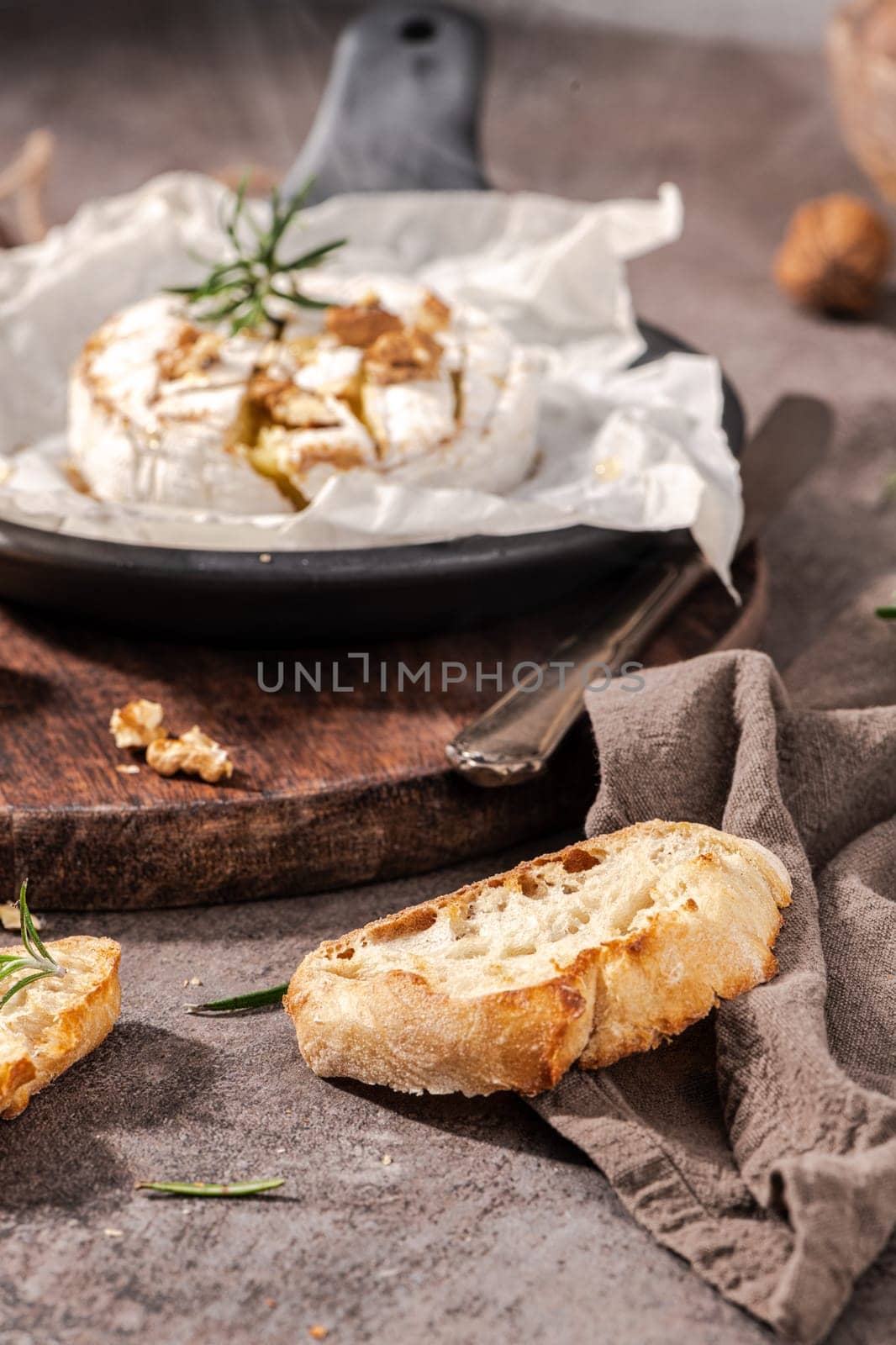 Brie type of cheese. Camembert cheese. Fresh sliced Brie cheese on a wooden tray with nuts, honey and leaves. Italian, French cheese.