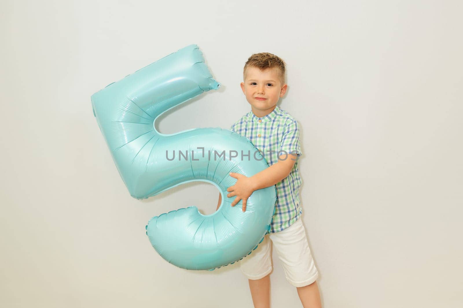 Boy with the number five for his birthday at home