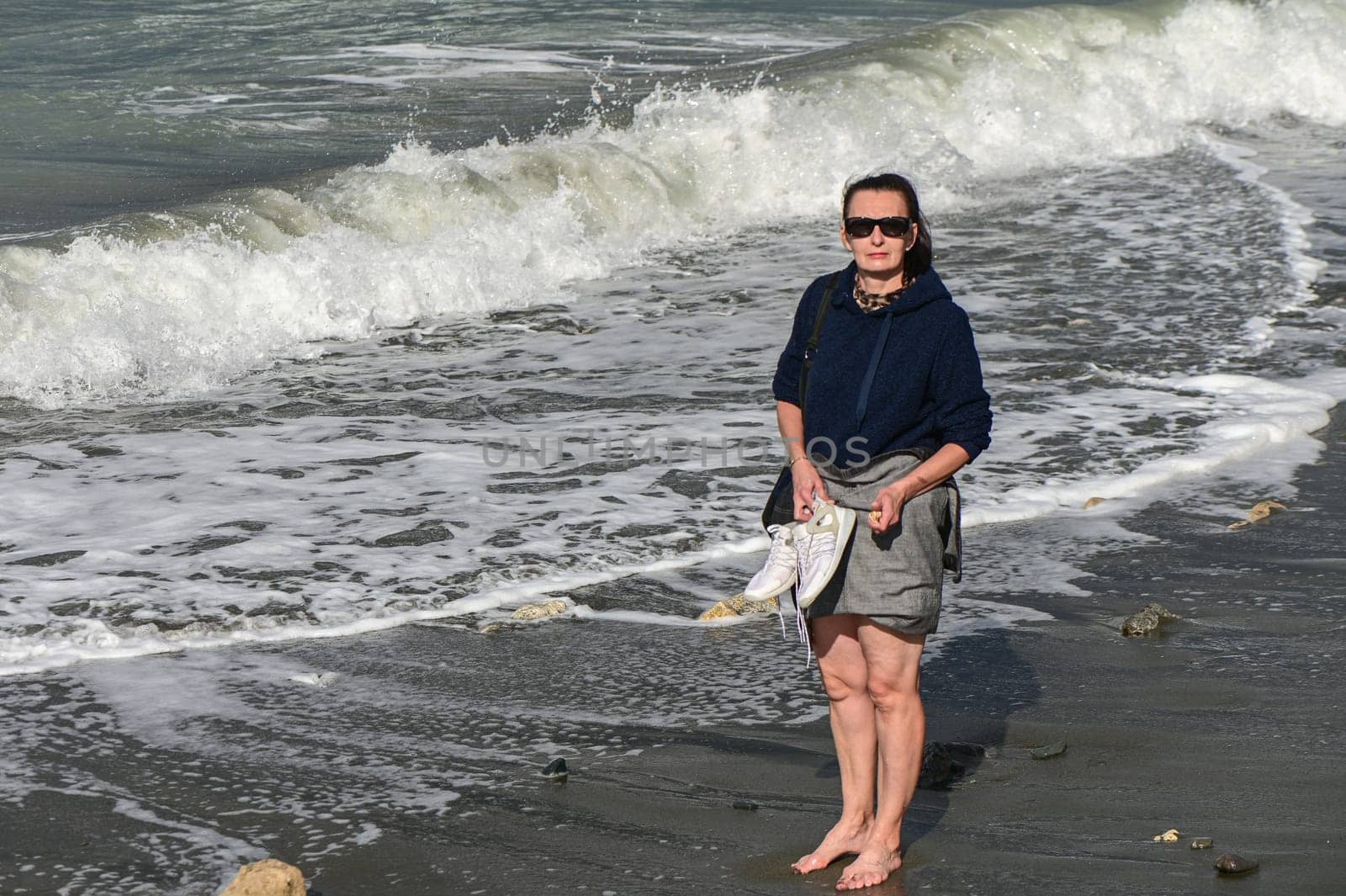 woman walks barefoot along the Mediterranean Sea in Cyprus in winter 2023 5