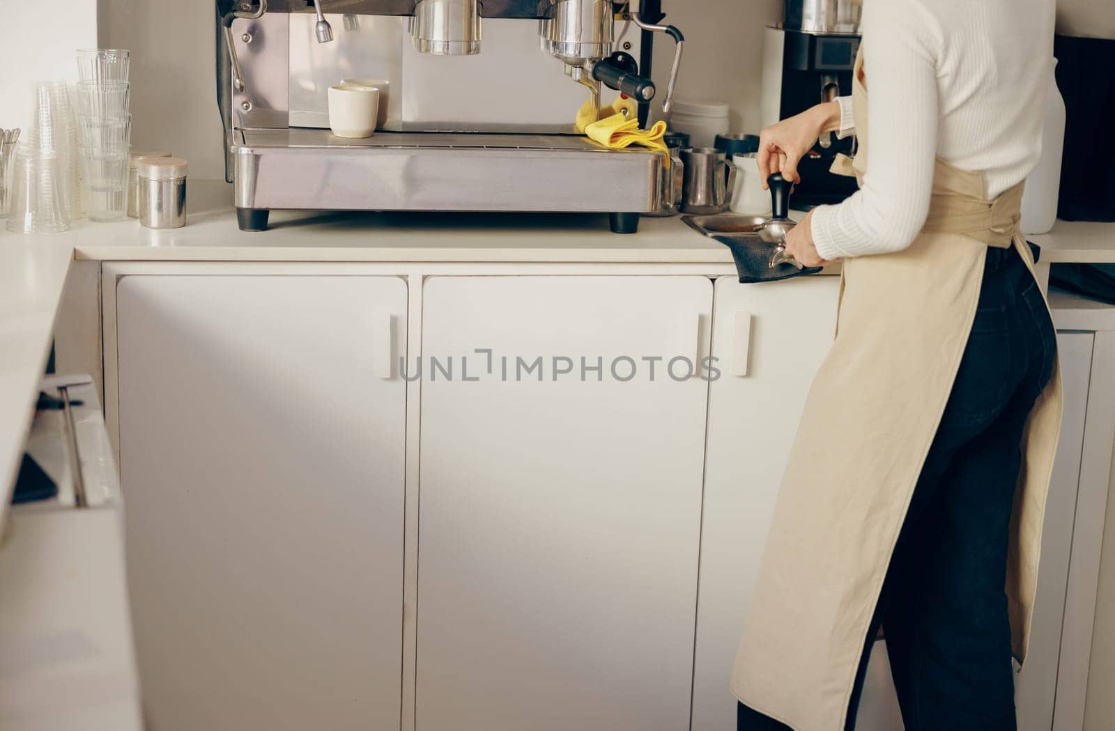 Close-up of barista making coffee with manual presses using tamper at the coffee shop by Yaroslav_astakhov