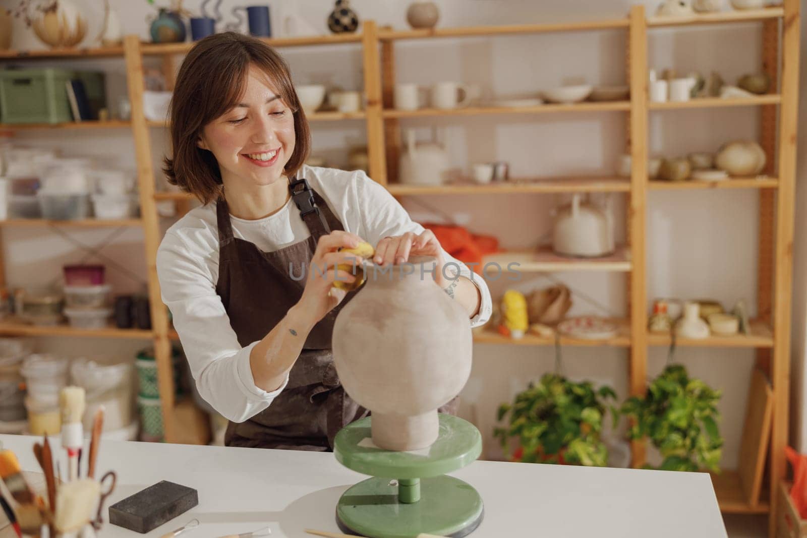 Professional female ceramist work with unfired clay vase in pottery studio. High quality photo by Yaroslav_astakhov