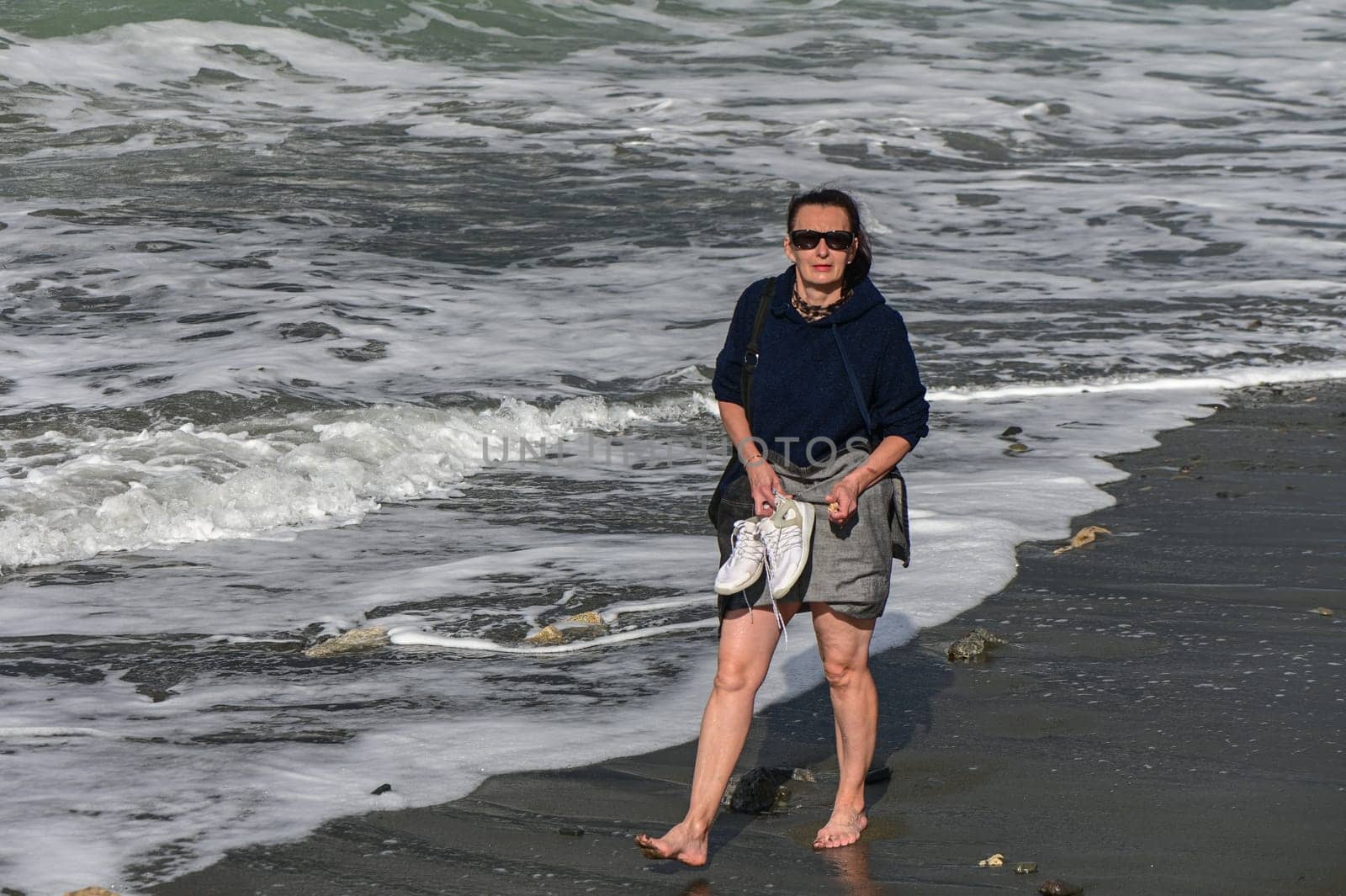 woman walks barefoot along the Mediterranean Sea in Cyprus in winter 2023 9 by Mixa74