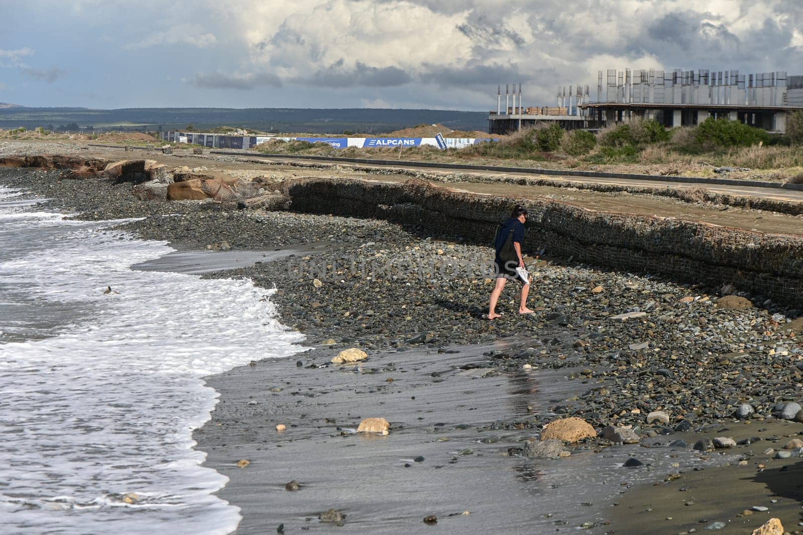 woman walking barefoot on the beach of the Mediterranean Sea in Cyprus in winter 5