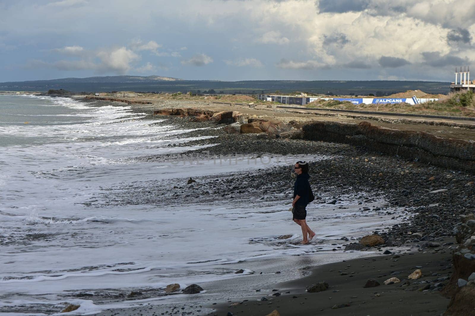 woman walks barefoot on the water in the Mediterranean Sea in Cyprus in winter 2023 1 by Mixa74