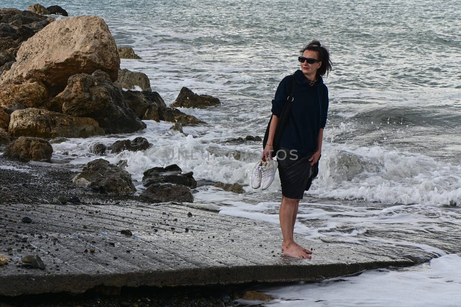 woman walks along the Mediterranean coast in Cyprus in winter 2023 4