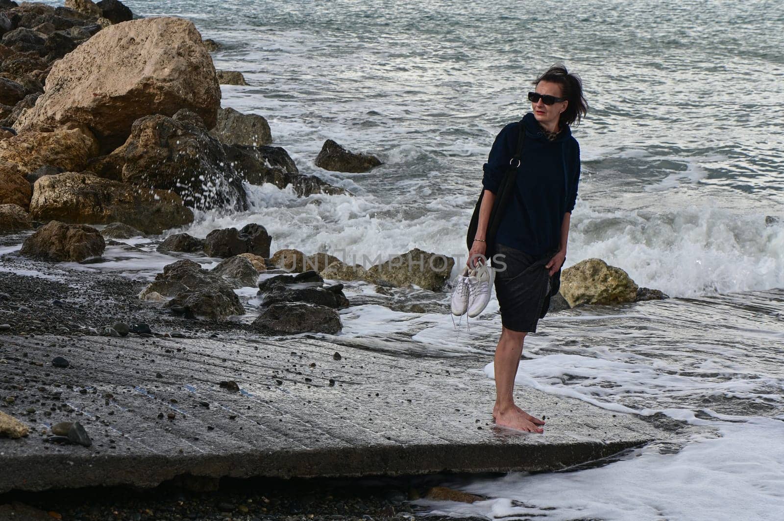 woman walks along the Mediterranean coast in Cyprus in winter 2023 4 by Mixa74