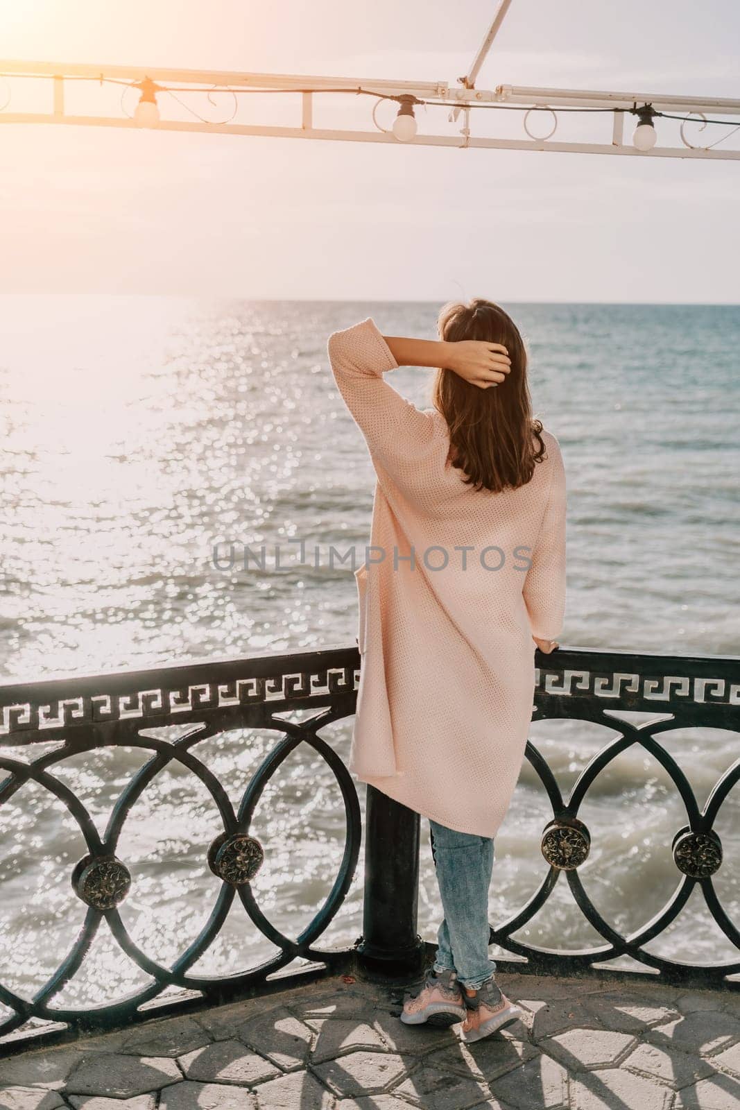 Woman summer travel sea. Happy tourist enjoy taking picture outdoors for memories. Carefree woman traveler posing on beach at sea on sunset, sharing travel adventure journey. Holiday vacation concept. by panophotograph