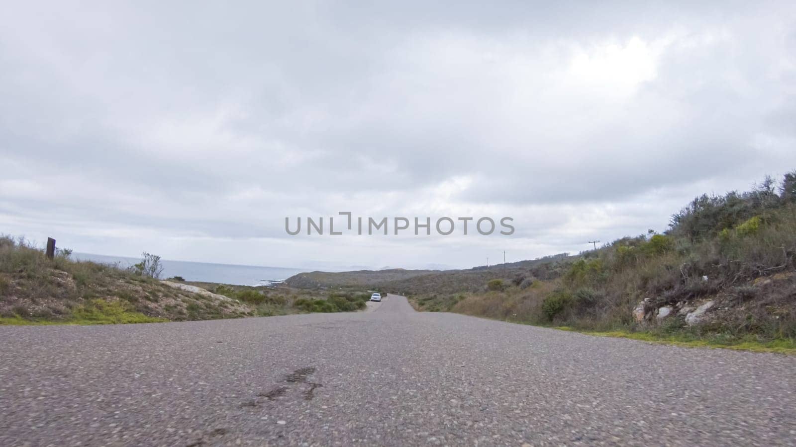 In this serene winter scene, a vehicle carefully makes its way along Los Osos Valley Road and Pecho Valley Road within Montana de Oro State Park.