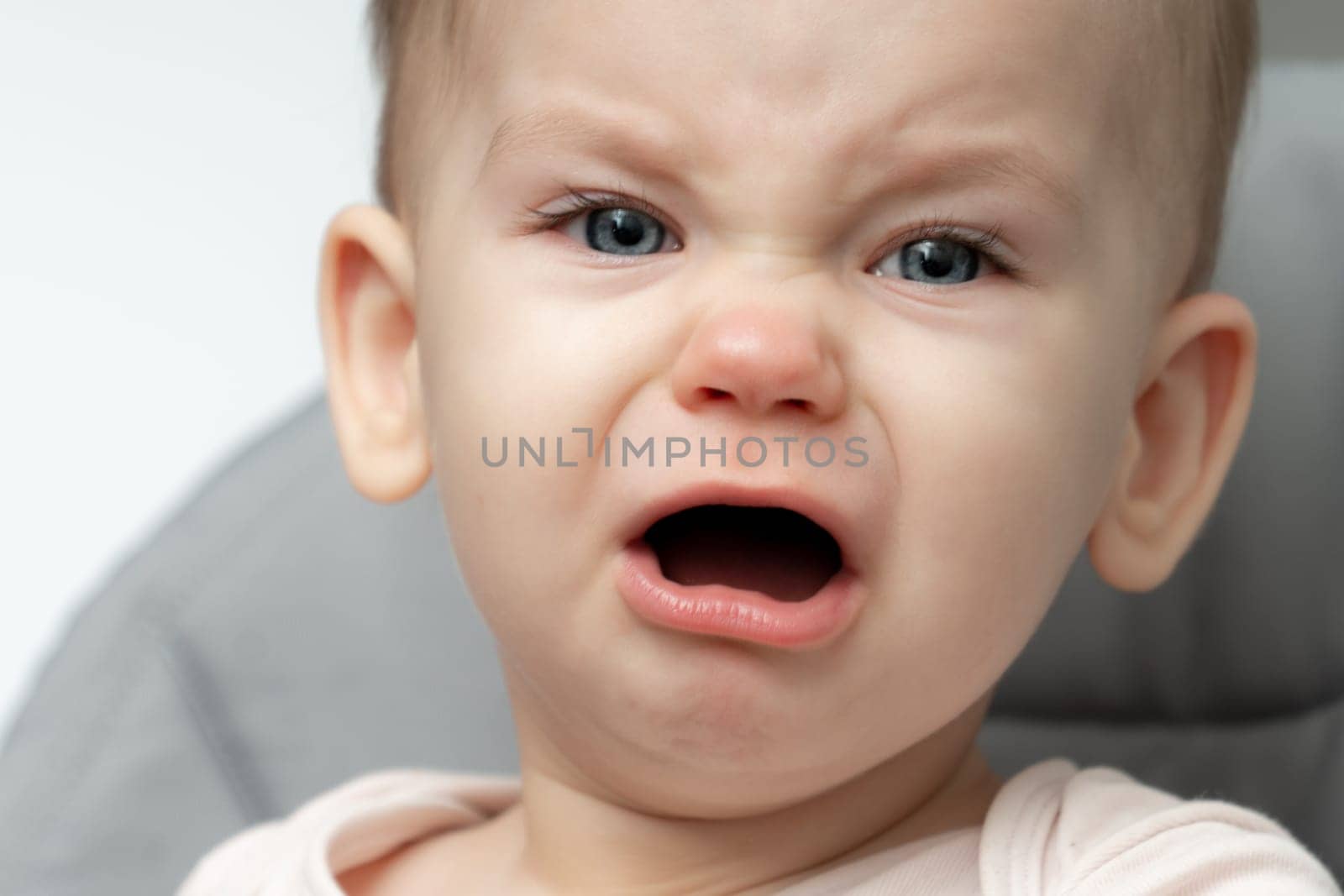 The closeup of an infant crying, showcasing the evident signs of being hungry and tired. Concept of the depth of parental love and the act of caring