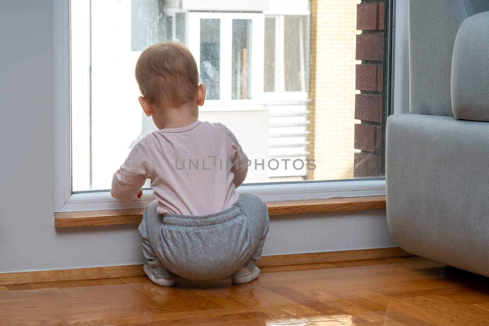 Little one looking out for dad's return. Concept of anticipation and family bonds by Mariakray