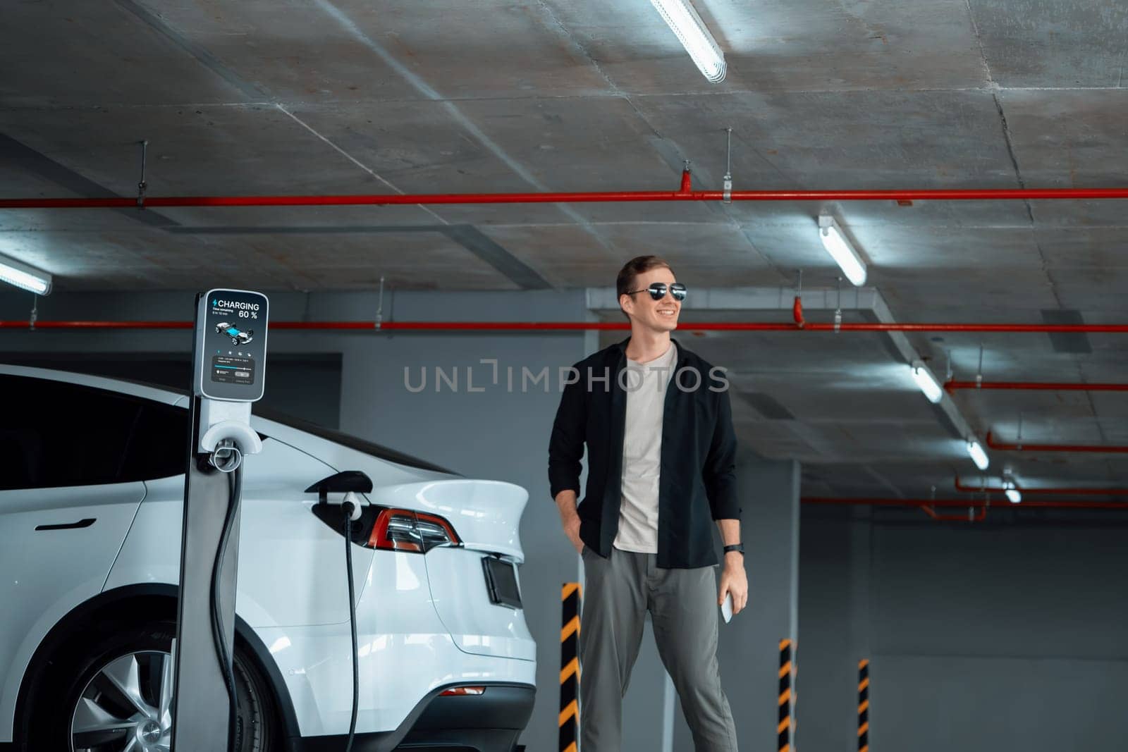 Young man travel with EV electric car to shopping center parking lot innards by biancoblue