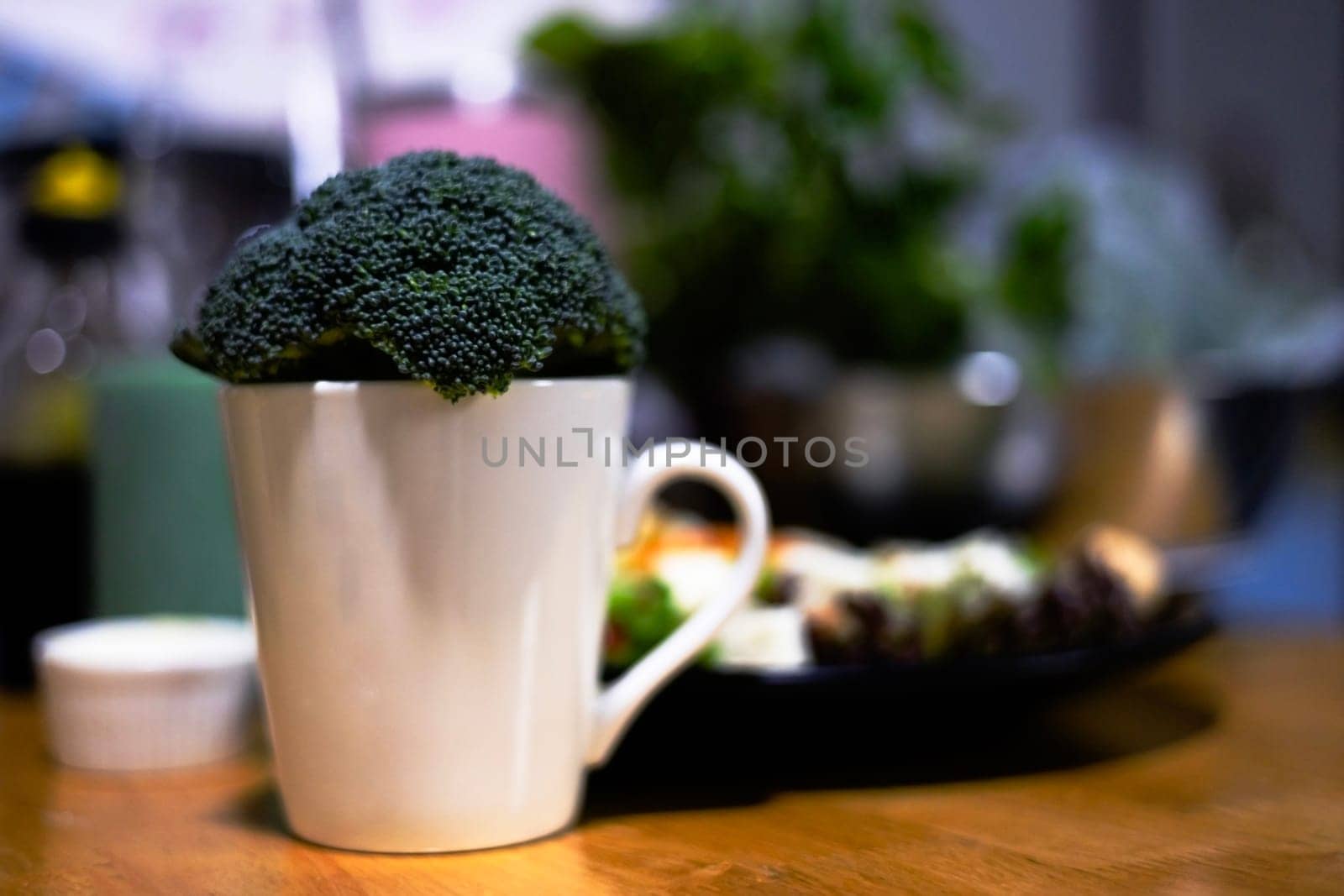 Fresh broccoli in a ceramic mug on blur background.