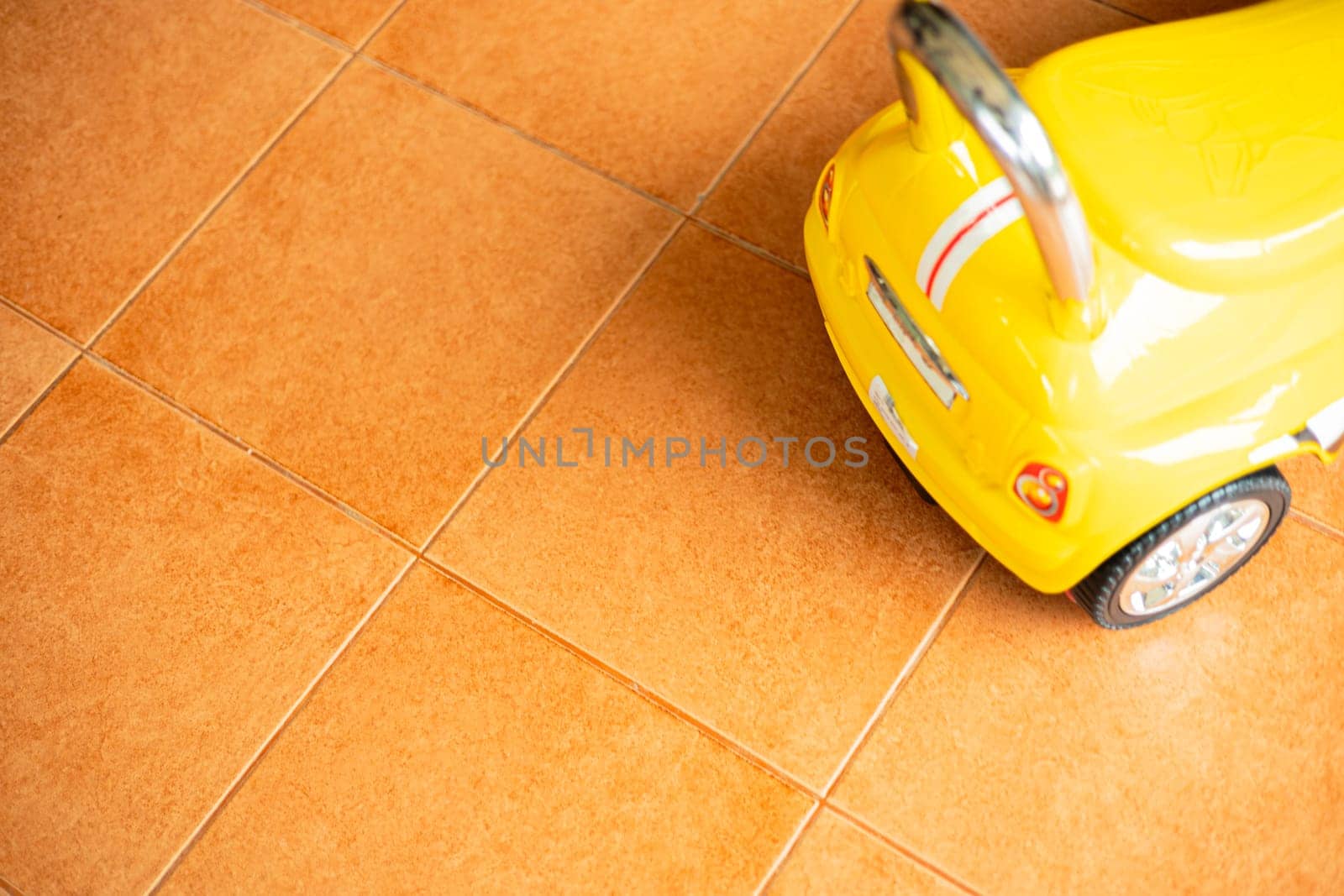 Yellow Toy Car Was Parked On The Tile Floor by urzine