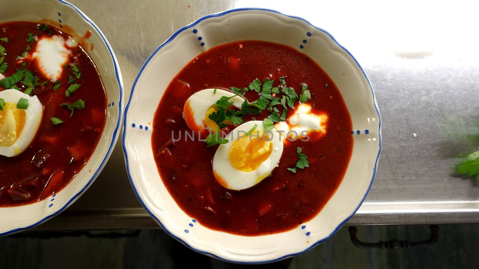 Homemade winter soup with tomatoes, beetroot, cream eggs and parsley.