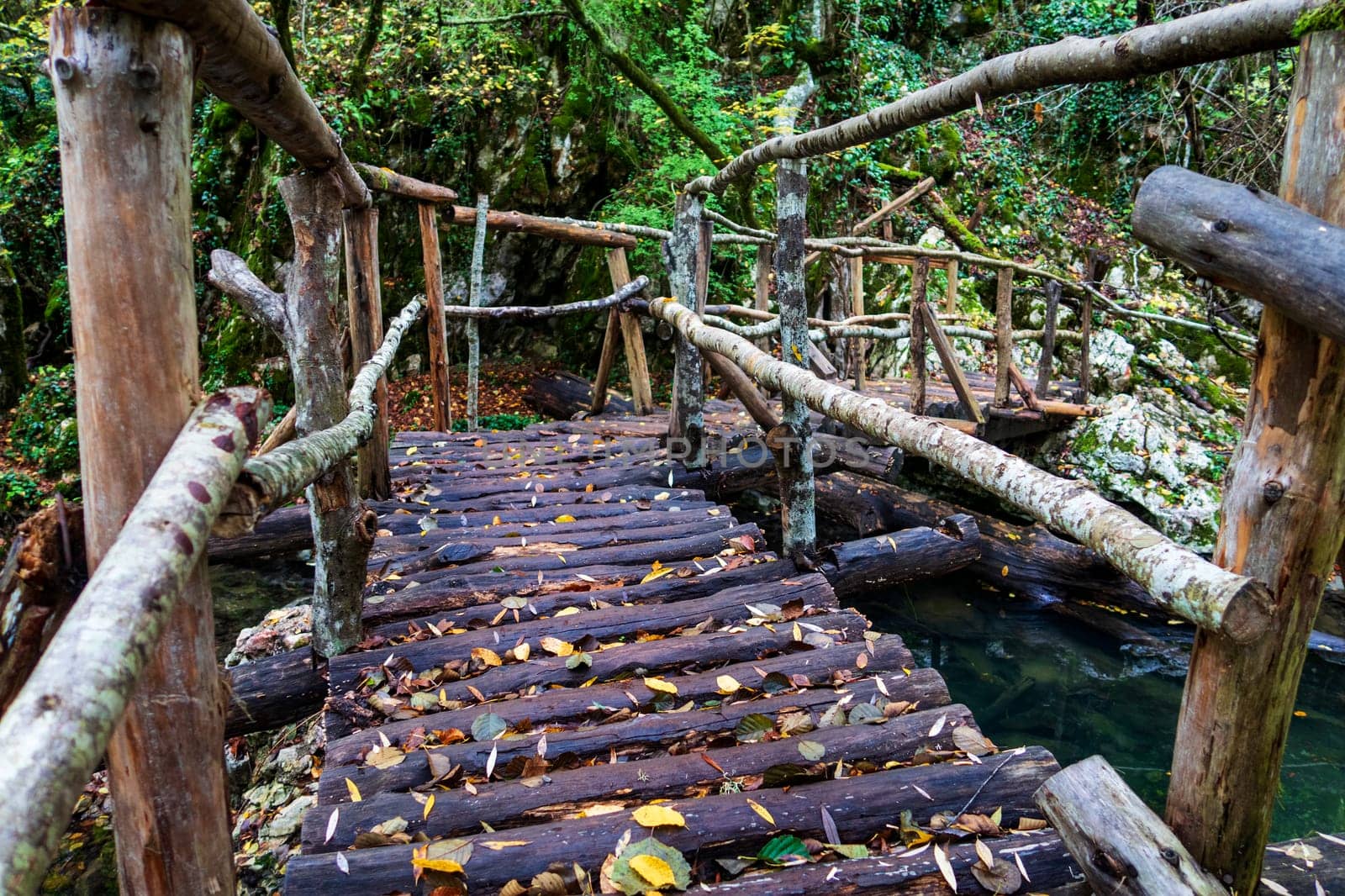 Wooden handmade bridge in the forest over river by EdVal
