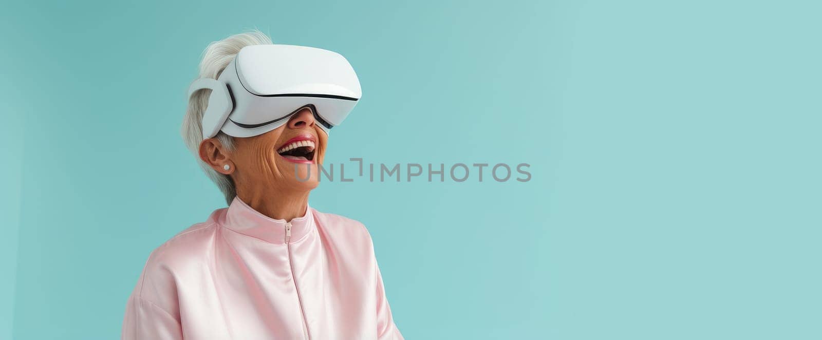 Portrait of a happy smiling enthusiastic Caucasian elderly old, senior woman grey-haired in a virtual reality headset on a blue background. by Alla_Yurtayeva