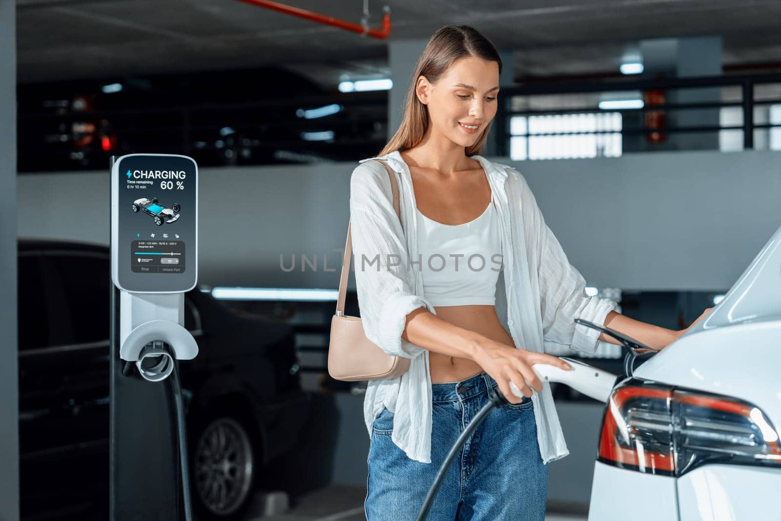 Young woman travel with EV electric car to shopping center parking lot charging in downtown city showing urban sustainability lifestyle by green clean rechargeable energy of electric vehicle innards