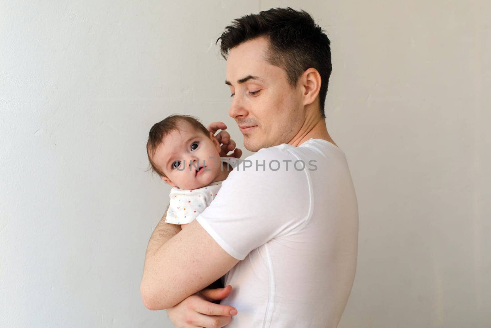 Content man with cute infant in bright room by Demkat