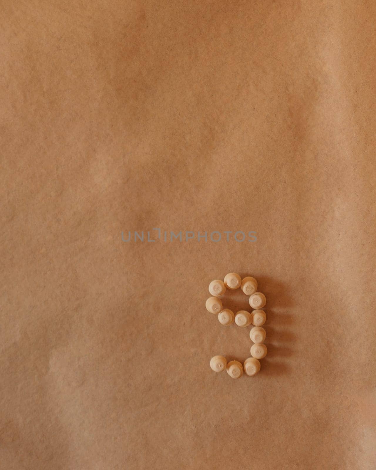 A minimalist composition of wooden pins forming the number nine on a brown background by apavlin
