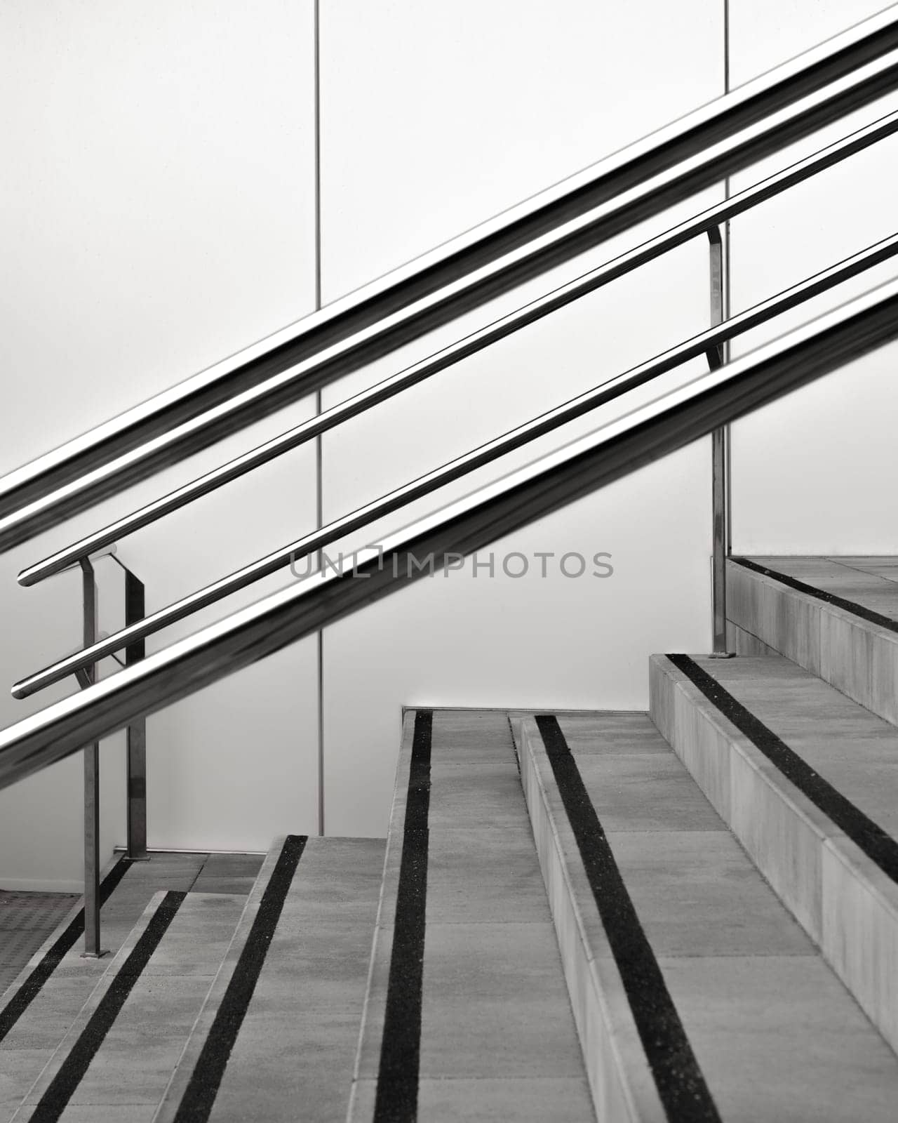 Modern stairway design with sleek metal handrails and contrasting steps in black and white by apavlin