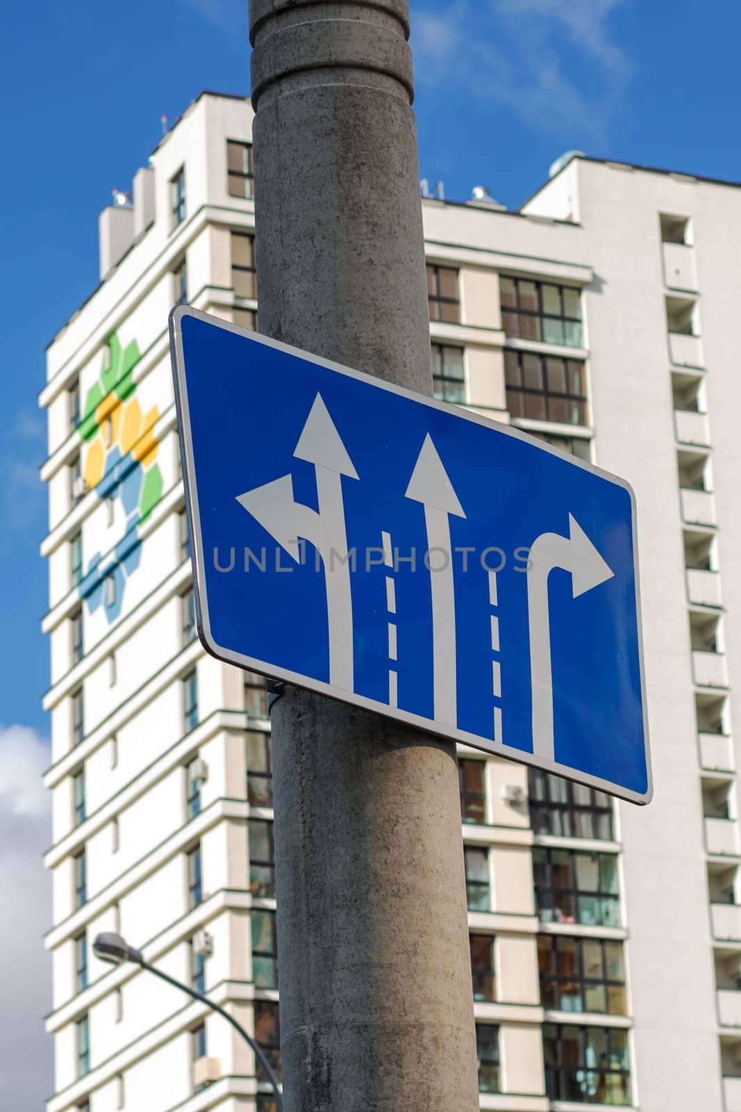 Blue road sign with arrow pointers close up