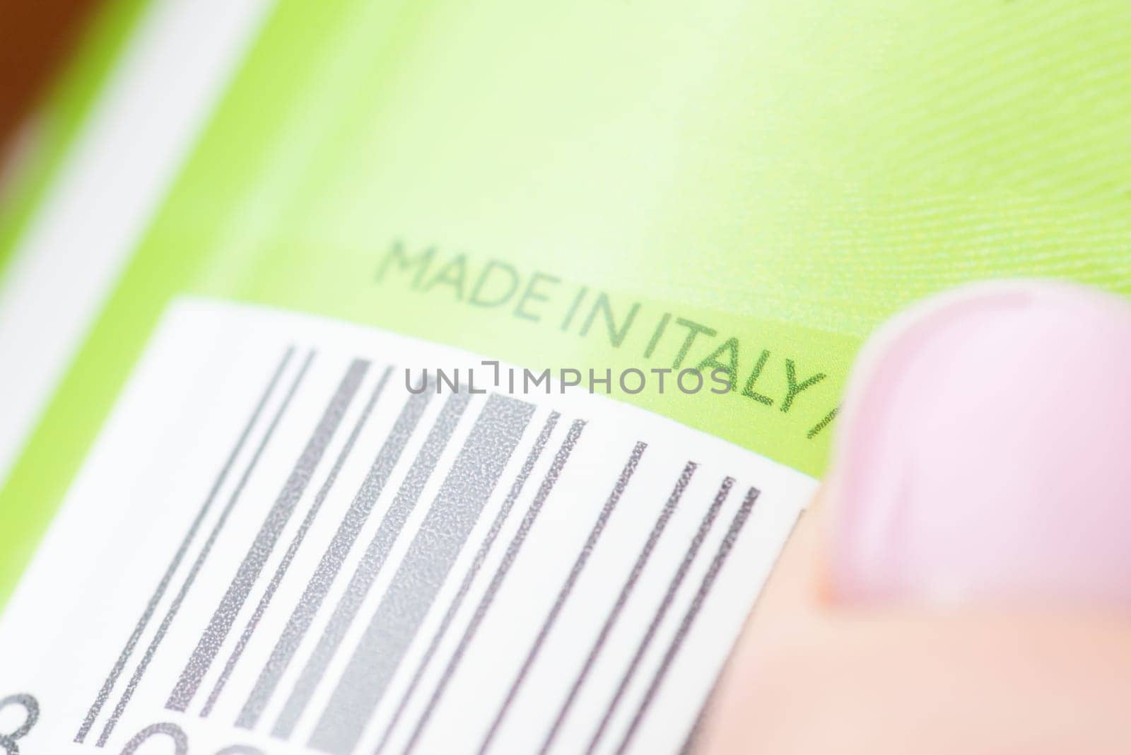 Green bottle with some cosmetics with label Made in Italy