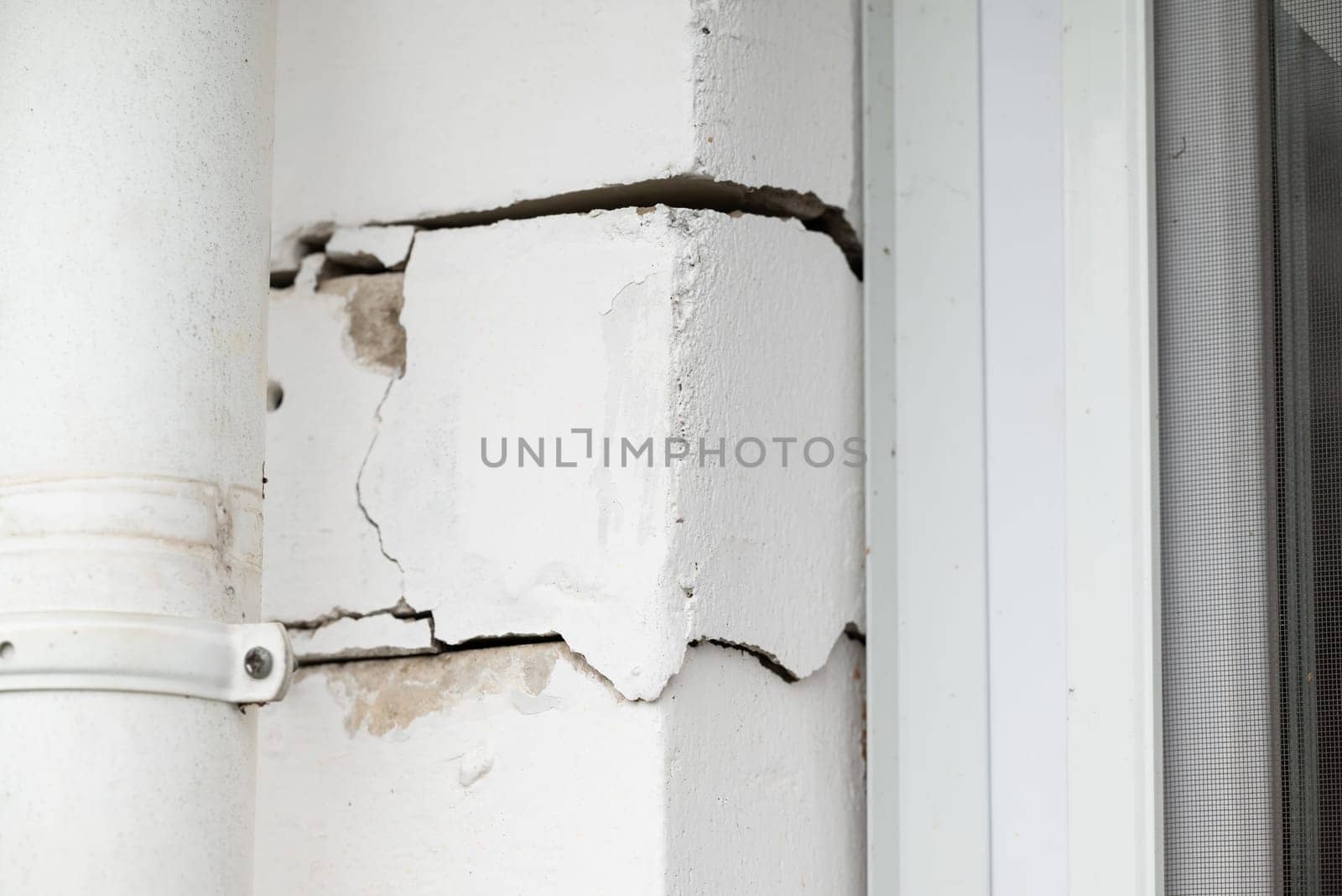Brick wall of a house with cracks, errors in building by VitaliiPetrushenko