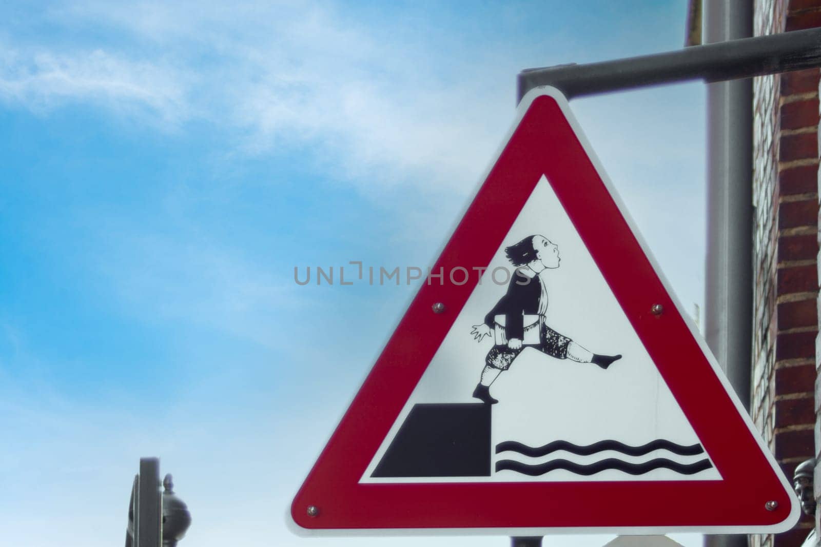 Sign warning about the danger of slipping into the water by Maksym