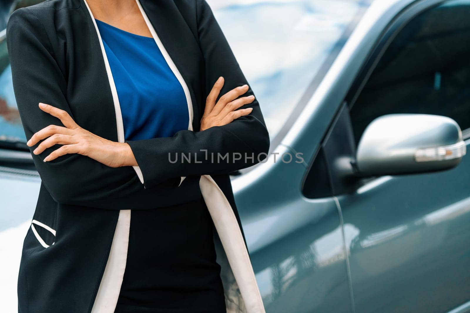 Confident business woman standing beside the car. uds by biancoblue