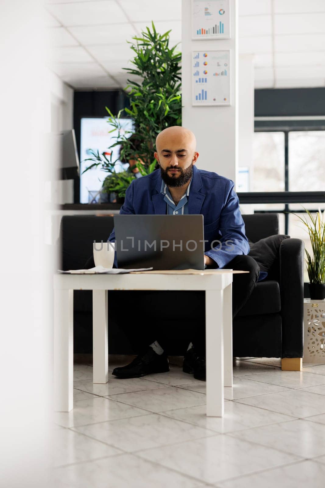Arab man startup business employee typing on laptop, analyzing marketing campaign. Company executive manager planning product sales strategy while working in coworking open space