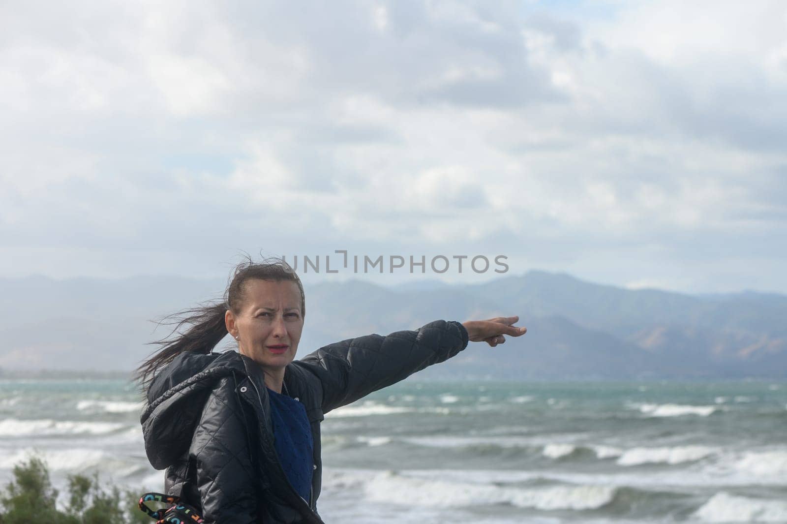 portrait of a woman pointing to the Mediterranean Sea in Cyprus