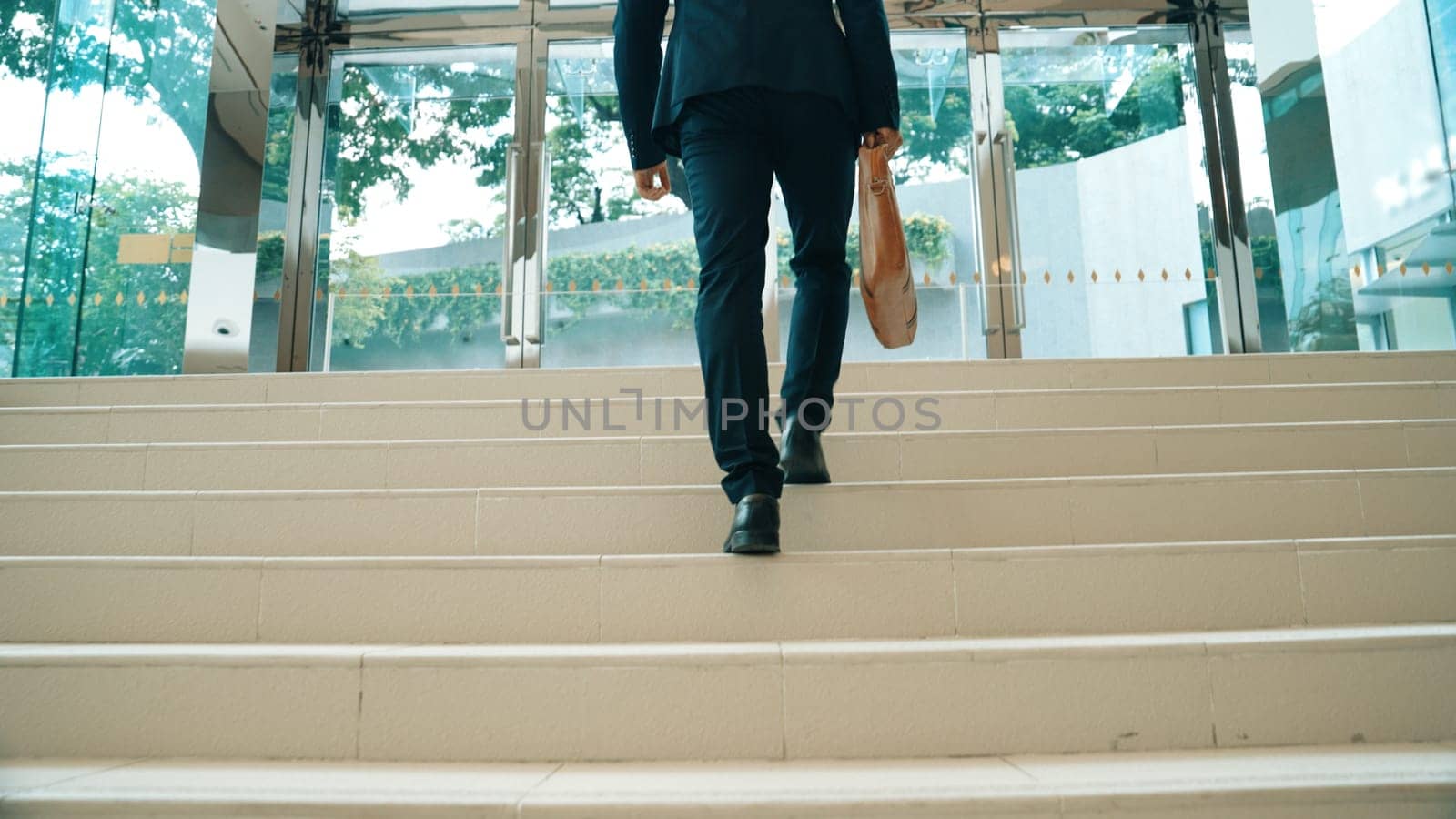 Closeup of business man leg go up the stairs. Successful man going up the stairs while explore a new thing. Traveling, getting a promotion, finding a new job, increasing skill. Back view. Exultant.