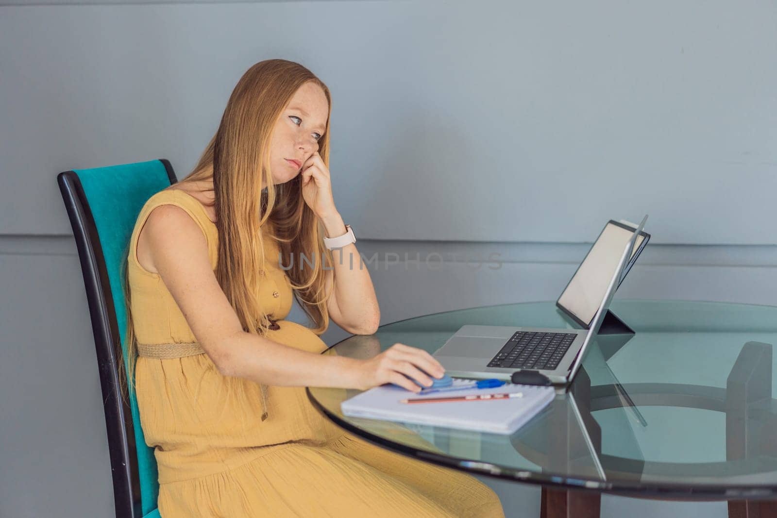 Beautiful pregnant woman working on laptop. Young businesswoman working in her office.