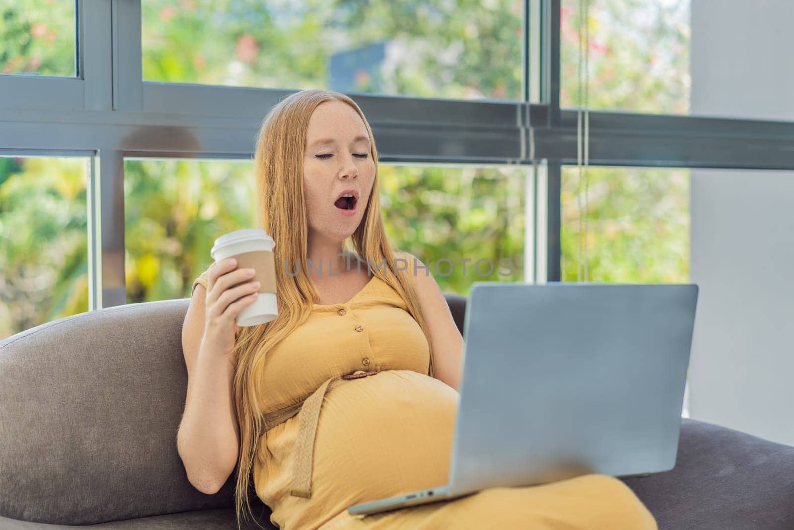 Tired pregnant woman at work drinks coffee caution advised due to potential harm of caffeine during pregnancy by galitskaya