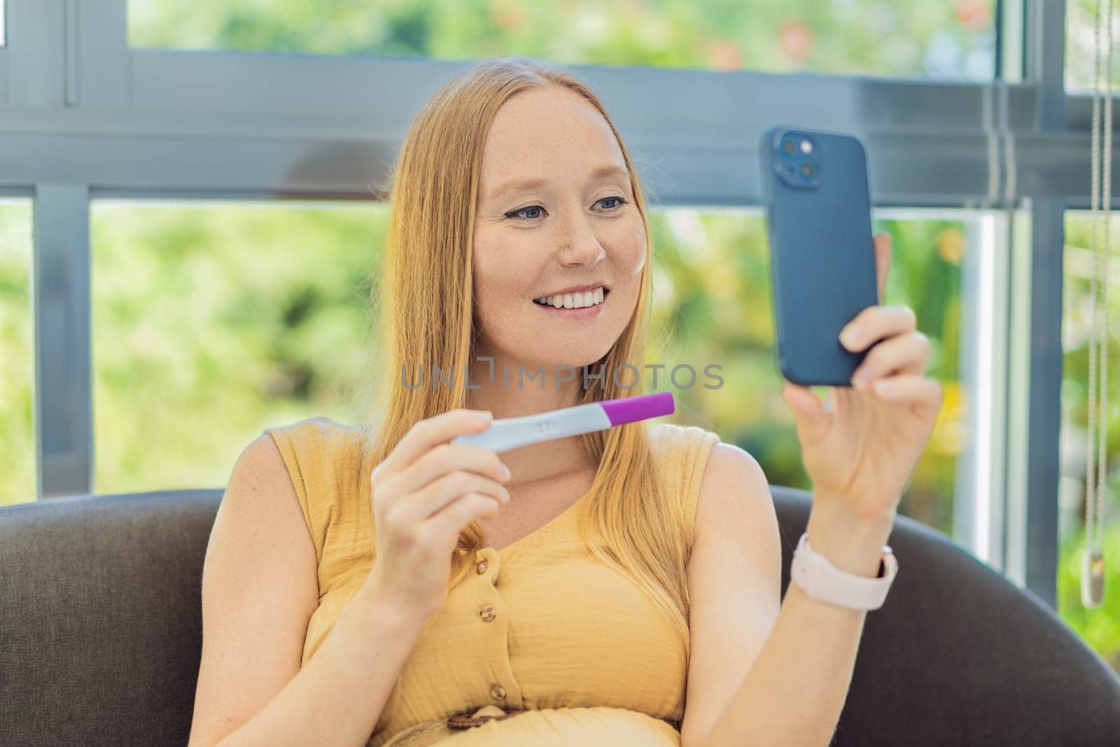 Expectant woman shares joyous news, showing her pregnancy test via video call with excitement and happiness by galitskaya