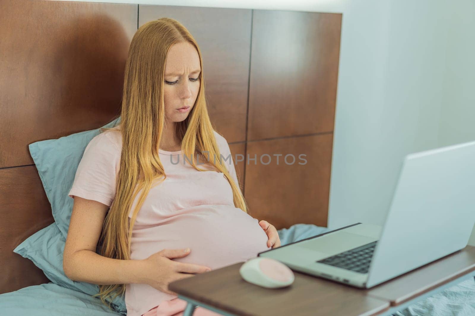 Weary pregnant woman, tired of working from home, navigates the challenges of balancing professional tasks with pregnancy demands.