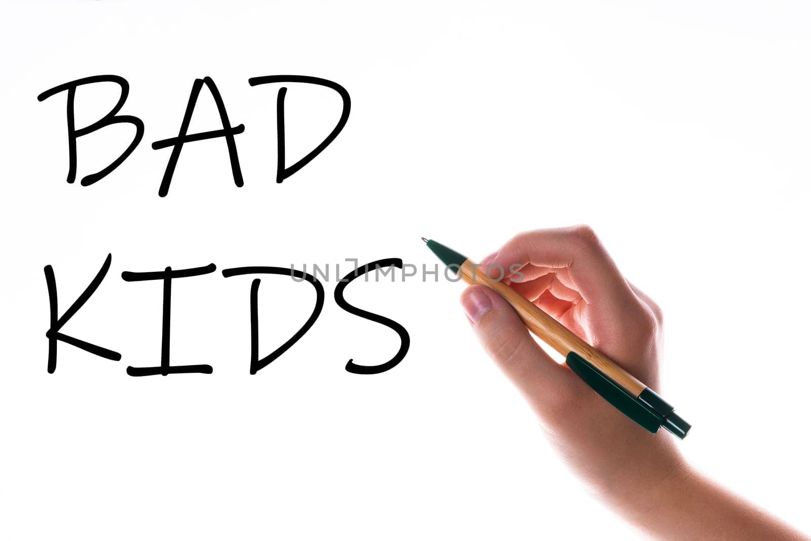 Children hand with pen write on an blue white background. Writing hand. Word Bad kids by Zelenin