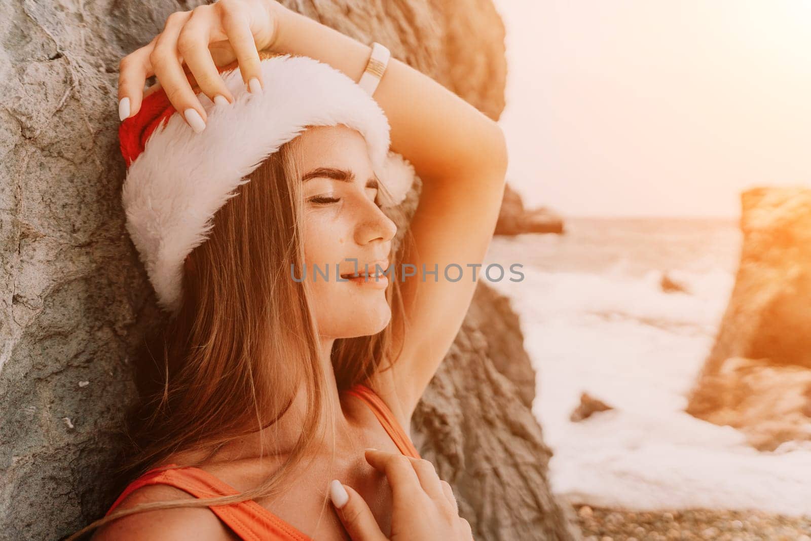 Woman travel sea. Young Happy woman in a long red dress posing on a beach near the sea on background of volcanic rocks, like in Iceland, sharing travel adventure journey