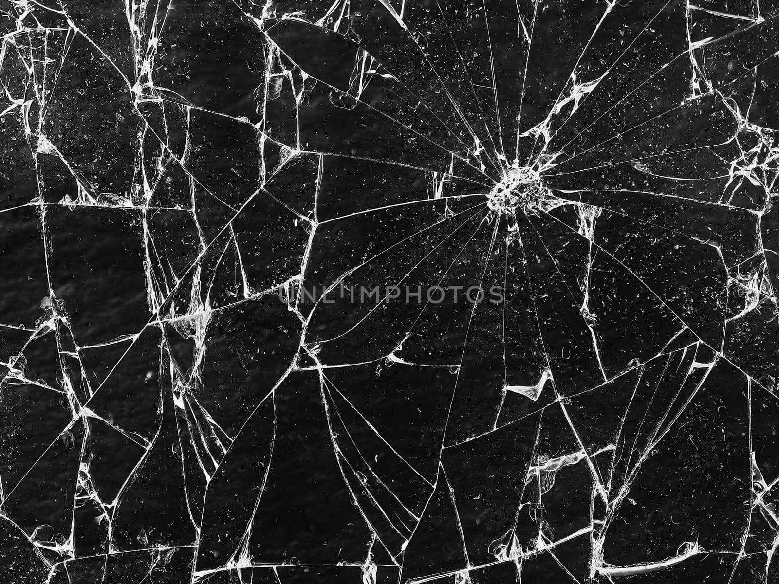 Shards of broken glass on a dark background reflecting highlights, chaotically scattered, some overlapping. Fractures and chips visible in places. Creates a sense of fragility and breaking apart into pieces.