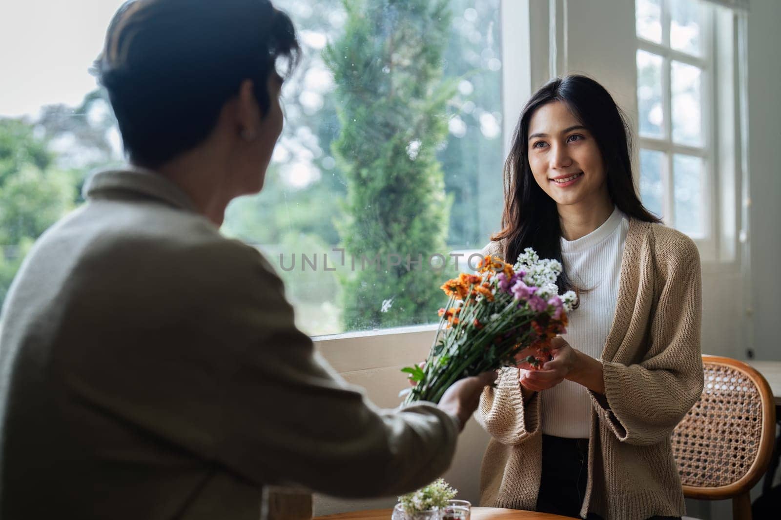 Young couple Hug and giving flower on Valentine's Day. Romantic day together. Valentine's Day concept by itchaznong