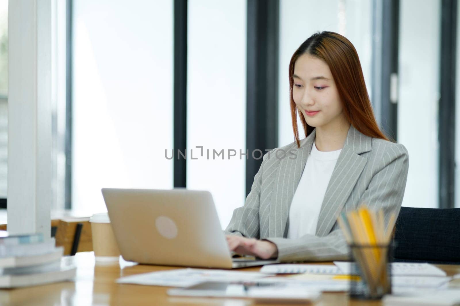 Business woman sitting working on her notebook with confidence and happiness doing a great job.